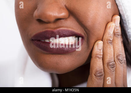 Close-up di una donna africana avente Dente dolore Foto Stock