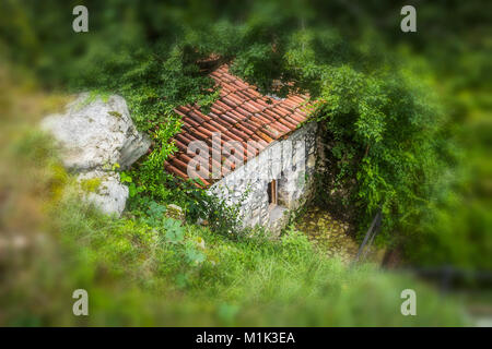 Una piccola casa di pietra sul pendio della montagna. La casa degli gnomi :-) Foto Stock