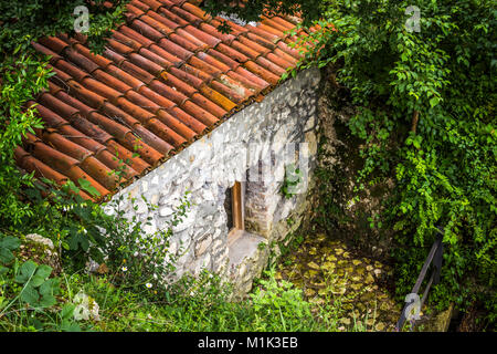 Una piccola casa di pietra sul pendio della montagna. La casa degli gnomi :-) Foto Stock