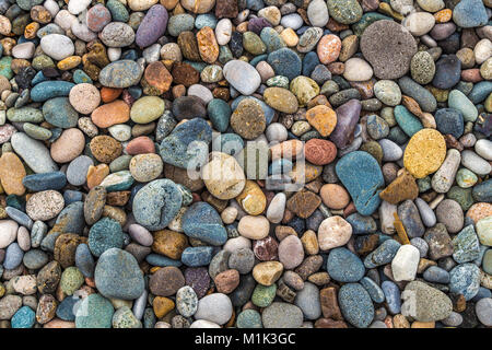 Un sacco di pietre colorate sulla banca del fiume di close-up come sfondo. Foto Stock