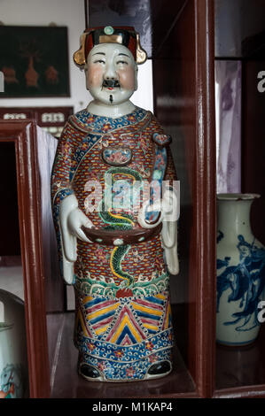 Un display in legno armadio visualizzando una ceramica figurina di un funzionario di governo. Parte di Wu Jianguo la collezione di antiche ceramiche cinesi. Trova Foto Stock