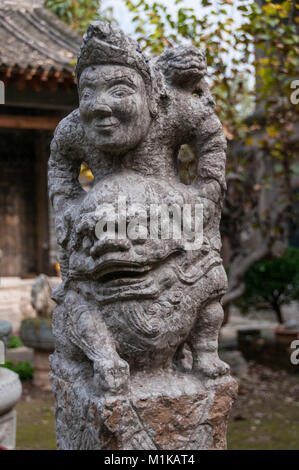 Un post statua di un uomo a cavallo di un leone come creatura. Parte di Wu Jianguo della collezione di antichi si trova nella zona rurale di Xi'an. Foto Stock