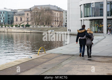 Giovane a piedi lungo il fiume Spree circondata dalla moderna architettura del quartiere governativo nella capitale tedesca Berlino Foto Stock