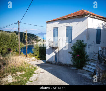 Dipinto di bianco di villa con persiane blu nel piccolo villaggio di pescatori di Kioni in greco isole Ionie Foto Stock