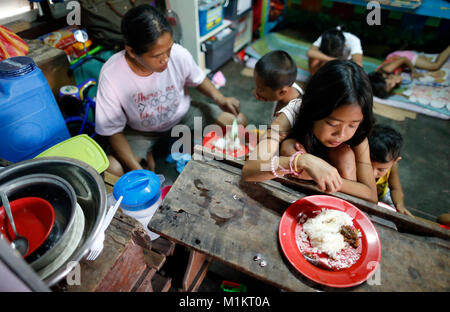 (180131) -- ALBAY, Gennaio 31, 2018 (Xinhua) -- Ellen Padova i bambini prendono il loro pranzo all'interno del centro di evacuazione in città Guinobatan in Albay, Filippine centrali, Gennaio 31, 2018. Ellen Padova fu tra le migliaia di persone sfollate dall'eruzione del paese il vulcano più attivo Mt. Mayon. Ella ha evacuato insieme con il marito Gabby e otto bambini, dal villaggio di Maninila, appena circa quattro chilometri di distanza dal cratere di Mt. Mayon. Attualmente la famiglia ha soggiornato per quasi tre settimane ora in una scuola elementare nella città Guinobatan insieme con altri 19 famiglie dal loro vill Foto Stock