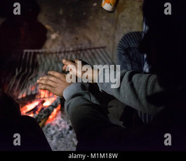 Kelebija, Serbia. 25 gennaio, 2018. In un'azienda abbandonata la casa vicino il confine ungherese di un migrante pakistano si riscalda se stesso da un incendio. Ungheria e Croazia sono stati a rafforzare i controlli di frontiera negli ultimi anni che ha portato in molti rifugiati e migranti inceppato in Serbia. Credito: Edward Crawford/SOPA/ZUMA filo/Alamy Live News Foto Stock