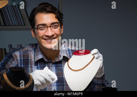 Giovane maschio gioielliere lavorando di notte nel suo laboratorio Foto Stock