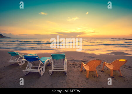 Spiaggia la sera con chaise longue Foto Stock