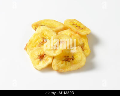 Cumulo di essiccato sottili fette di banana su sfondo bianco Foto Stock