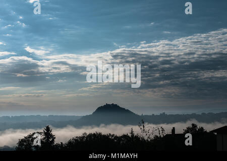 Campobasso, Italia, al crepuscolo skyline in un giorno di nebbia. Castello Monforte e monti silhouette Foto Stock