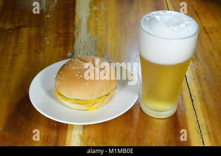 Cheeseburger e birra sul tavolo Foto Stock