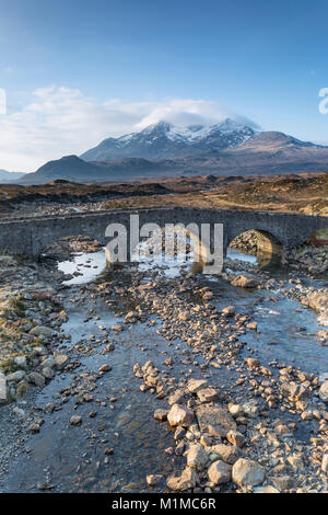 Il Cuillin Hills e il vecchio ponte di Sligachan, Isola di Skye in Scozia. Il vertice di Sgurr nan Gillian (964 m) è visibile attraverso le nuvole. Foto Stock