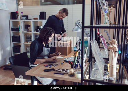 Maestri che rendono i gioielli di vetro veneziano nel loro laboratorio. Foto Stock