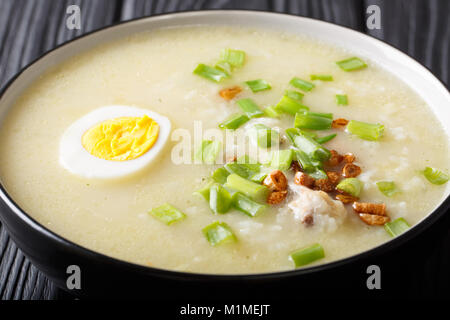 Arroz Caldo zuppa di riso, pollo e le uova in una terrina e orizzontale Foto Stock