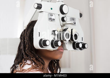 Close-up di una ragazza facendo prova di occhio su Phoropter Foto Stock