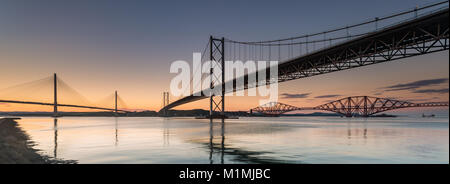 Forth Road e i ponti ferroviari e il ponte di Queensferry Crossing al tramonto, Fife, Scozia, Regno Unito Foto Stock