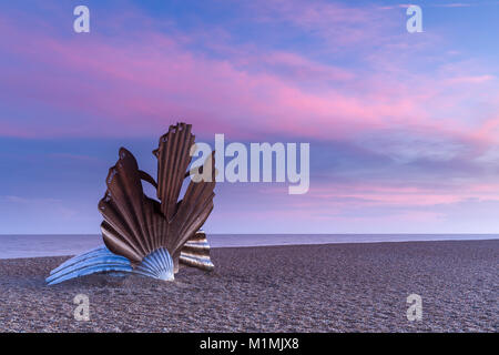 Scaloppina scultura Shell al tramonto con il bellissimo cielo rosa sulla spiaggia di Aldeburgh nel Suffolk, Inghilterra Foto Stock