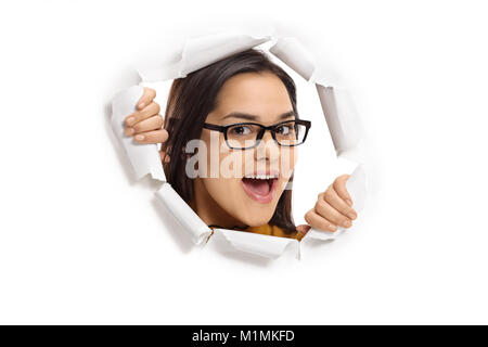 Ragazza adolescente sbirciando attraverso un foro della carta Foto Stock