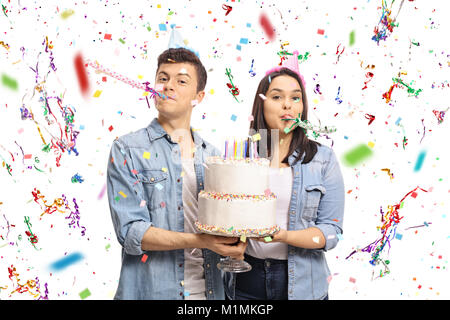 Gli adolescenti con una torta di compleanno e party corna isolati su sfondo bianco Foto Stock