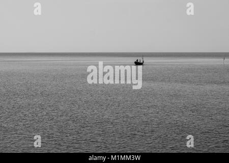 Abstract in bianco e nero e il minimo Concetto di immagine di lonely barca da pesca galleggiante sul mare. Foto Stock
