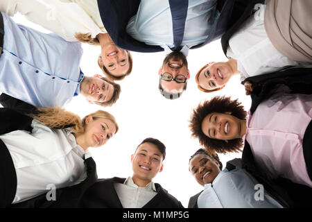 Basso angolo di vista happy businessman formando Huddle Foto Stock