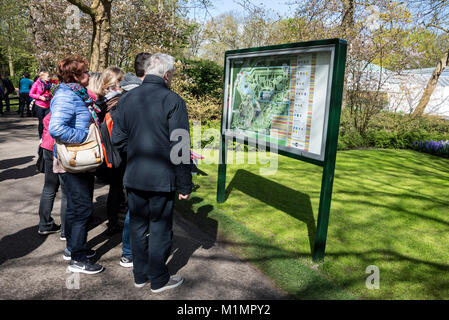 Guarda i visitatori in uno dei tanti visualizzare mappe in giardini Keukenhof, Lisse nel sud dell'Olanda. Il nome, ÔKeukenhofÕ il significato di "Cucina giardino", Foto Stock