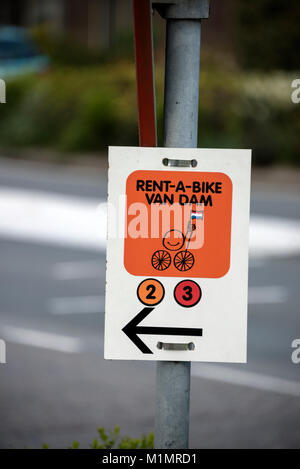 Un noleggio bici segno per il beneficio del ciclista sulla noleggiato biciclette tenendo il campo di tulipani rotta vicino Keukenhoft in Olanda. Foto Stock