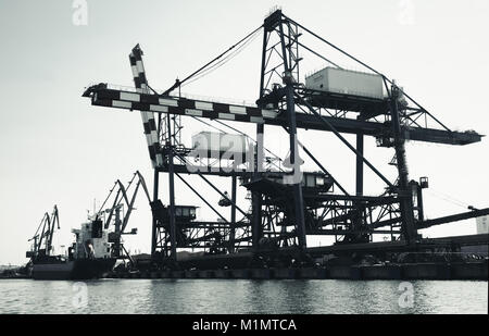 Gantry cranes nel porto di Burgas, il litorale del Mar Nero, Bulgaria. Vintage tonica foto in bianco e nero Foto Stock