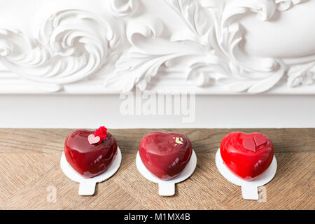 Il giorno di San Valentino o compleanno biglietto di auguri. Partita un dessert nella forma di un cuore rosso. Il dessert su vintage tavolo in legno Foto Stock