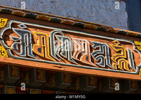 Bumthang, Bhutan. Legno intagliato iscrizione sopra ingresso Jambay Lhakhang (Monastero/tempio). Foto Stock