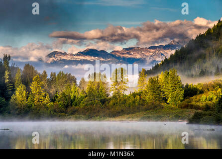 Bear Lake, nebbia di sunrise, inglese Pk e Mt Denver in dist, Selkirk Mtns, Zincton dividere zona, vicino Retallack città fantasma, British Columbia, Canada Foto Stock