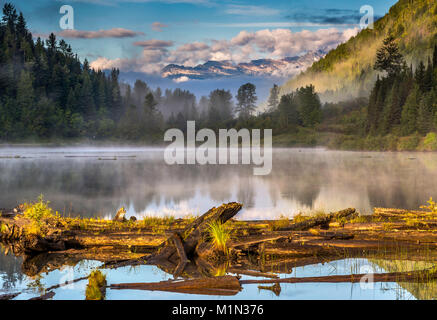 Bear Lake, nebbia di sunrise, inglese Pk e Mt Denver in dist, Selkirk Mtns, Zincton dividere zona, vicino Retallack città fantasma, British Columbia, Canada Foto Stock