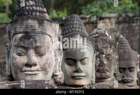 Facce di dio statue sulla balaustra del cancello sud causeway, Angkor Thom, Cambogia Foto Stock