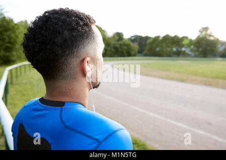 Atleta maschio al via lo sguardo lontano, vicino, vista posteriore Foto Stock