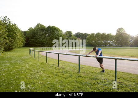 Atleta maschio stiro a via di corsa a piena lunghezza Foto Stock