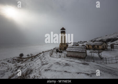 Il vecchio faro di legno a bordo del porto di congelati con cielo molto nuvoloso Foto Stock