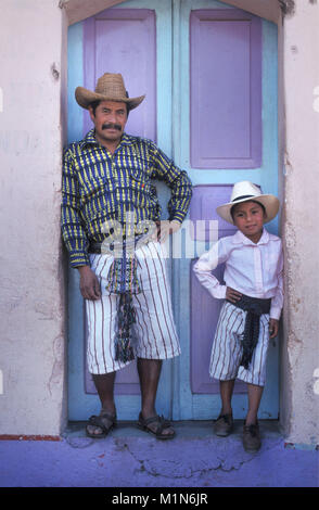 Guatemala. Santiago de Atitlšn. Lago de Atitlan. Maya uomo e figlio in piedi in porta. Foto Stock