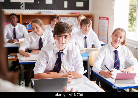 Gli studenti ascolto alle femmine di insegnante in classe Foto Stock