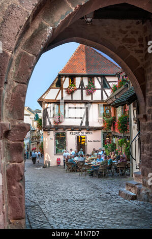 RIQUEWIHR medievale di pietra ingresso ad arco a Riquewihr uno storico popolare villaggio floreale con ristoranti e bar sulla Route des Vins Alsace Francia Foto Stock