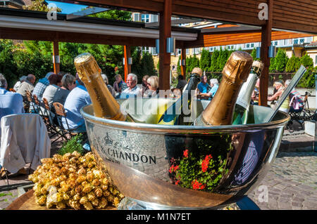 Ristorante Alfresco bottiglie di Champagne la refrigerazione per ospiti in grandi wine cooler all'esterno soleggiato ristorante terrazza tabella Francia Foto Stock