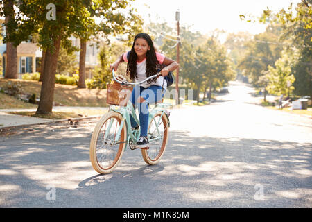 Ragazza Bicicletta Equitazione lungo la strada alla scuola Foto Stock