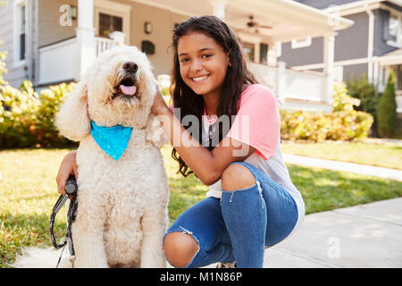 Ritratto di ragazza con cane sulla strada suburbana Foto Stock