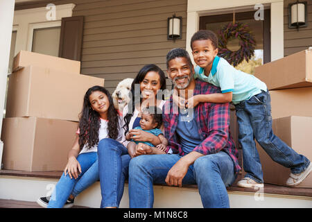 Famiglia con bambini e cane fuori casa sul giorno del trasloco Foto Stock