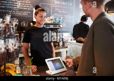 Il cliente di pagare in Coffee Shop utilizzando la carta di credito Foto Stock