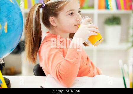 Ragazza giovane di bere succo di frutta a casa Foto Stock