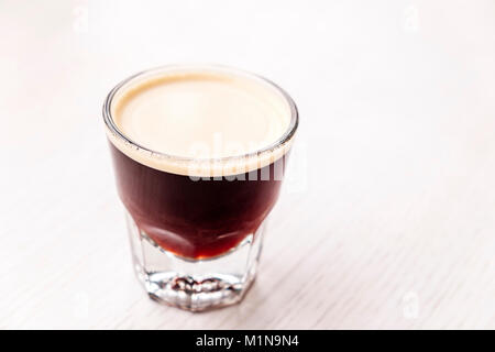 Birra fredda caffè espresso in tazza di vetro su sfondo bianco Foto Stock