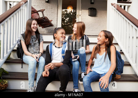 Young Teen girls sulla parte anteriore passi di casa con la scuola di sacchi Foto Stock