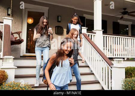 Quattro amiche teen di lasciare casa per la scuola Foto Stock