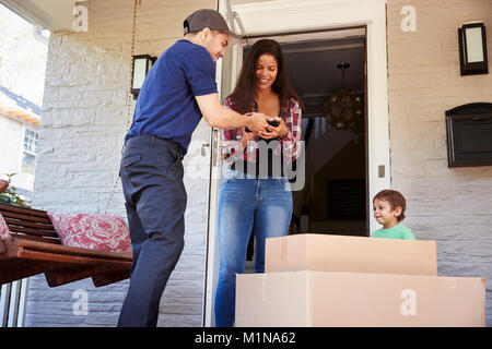 Corriere donna chiede di confermare la consegna su tavoletta digitale Foto Stock