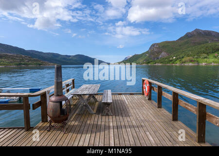 Tavolo da picnic in un molo con barbecue lungo la contea norvegese Road 17 da Bodo a Halsa. Norvegia Foto Stock